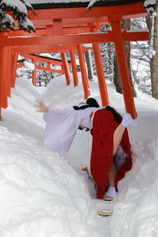 穿白色吉莫诺的女人在雪地上行走。