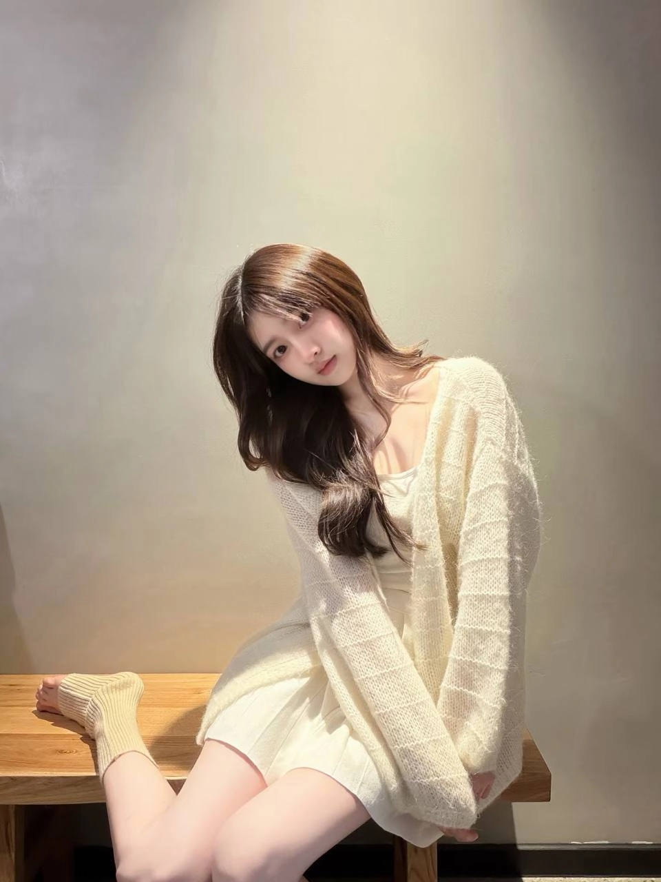 穿白色衬衫的女人坐在一个凳子上。