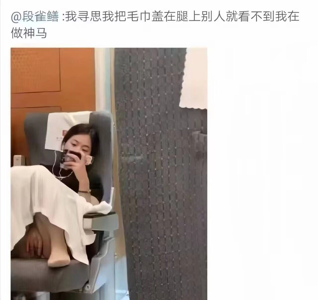穿着白色衣服的女人坐在椅子上,看着她的手机。