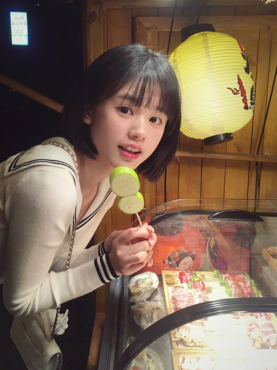 女人拿着一颗绿苹果和一根玉米杖。