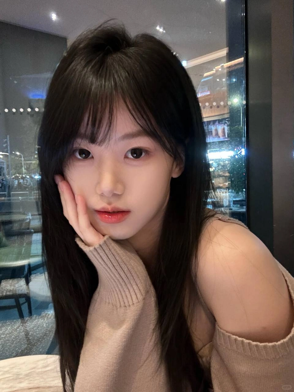 长黑头发和粉红色的唇膏的女人对相机微笑。