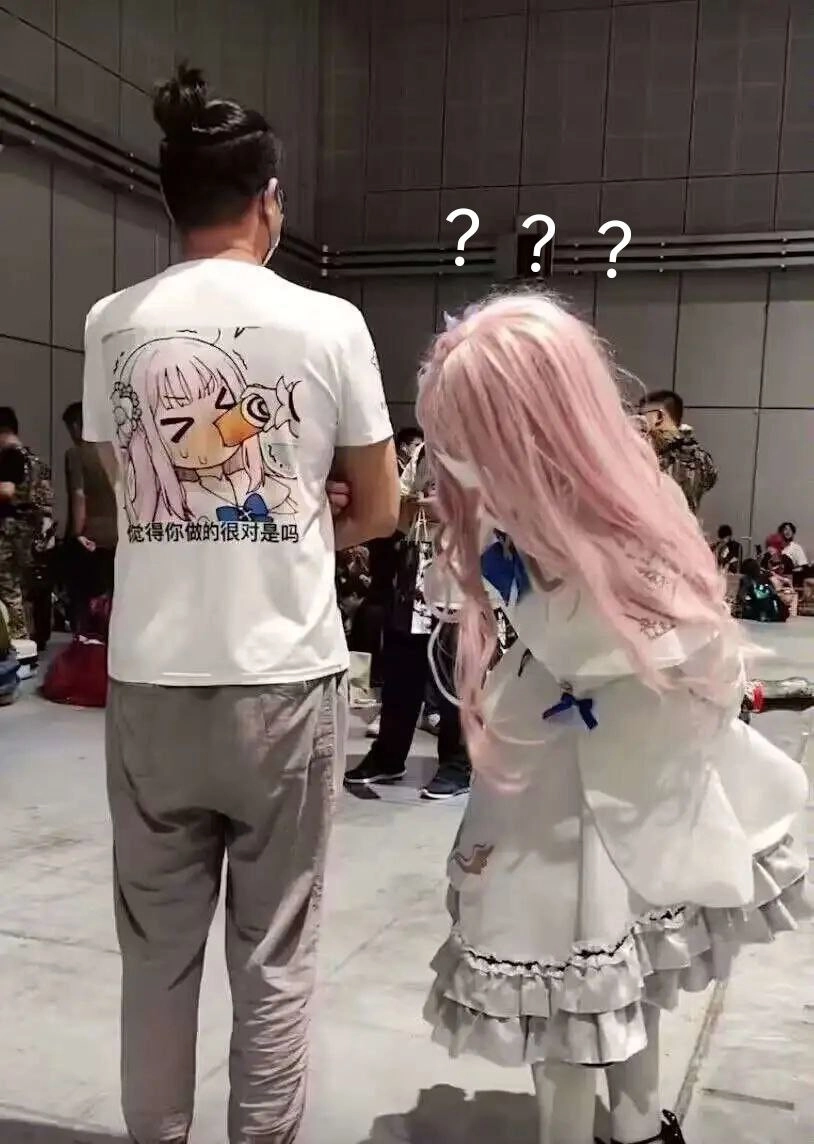 带着一只鸟在衬衫上,站在一个红头发的女人旁边。