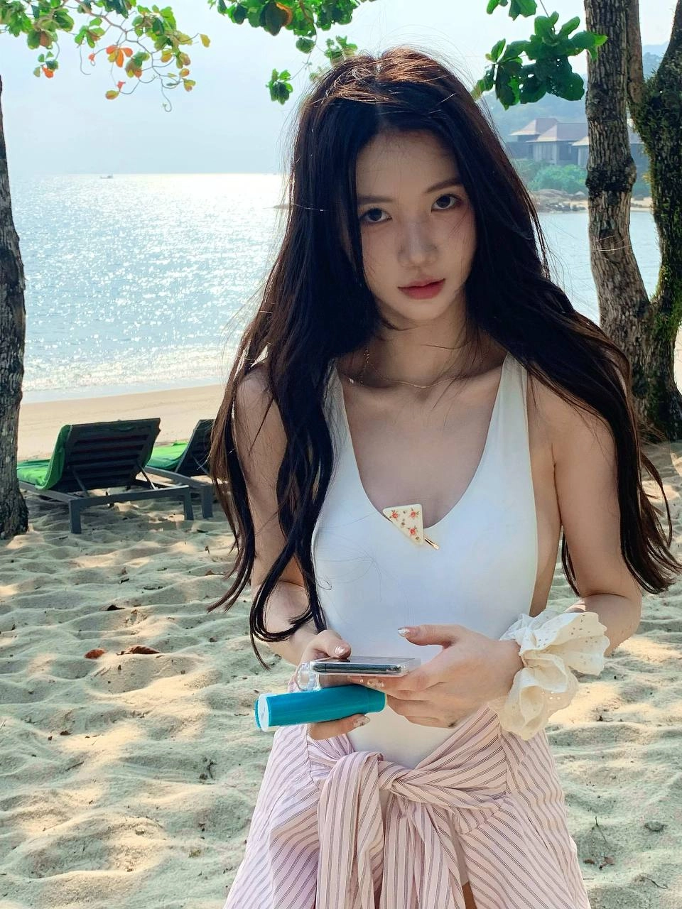 一位穿着白色浴衣的女人拿着手机。