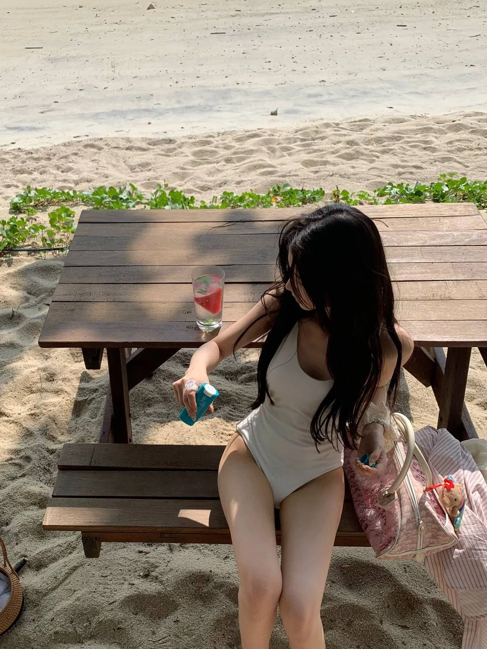 穿着白色衣服的女人坐在沙子上。