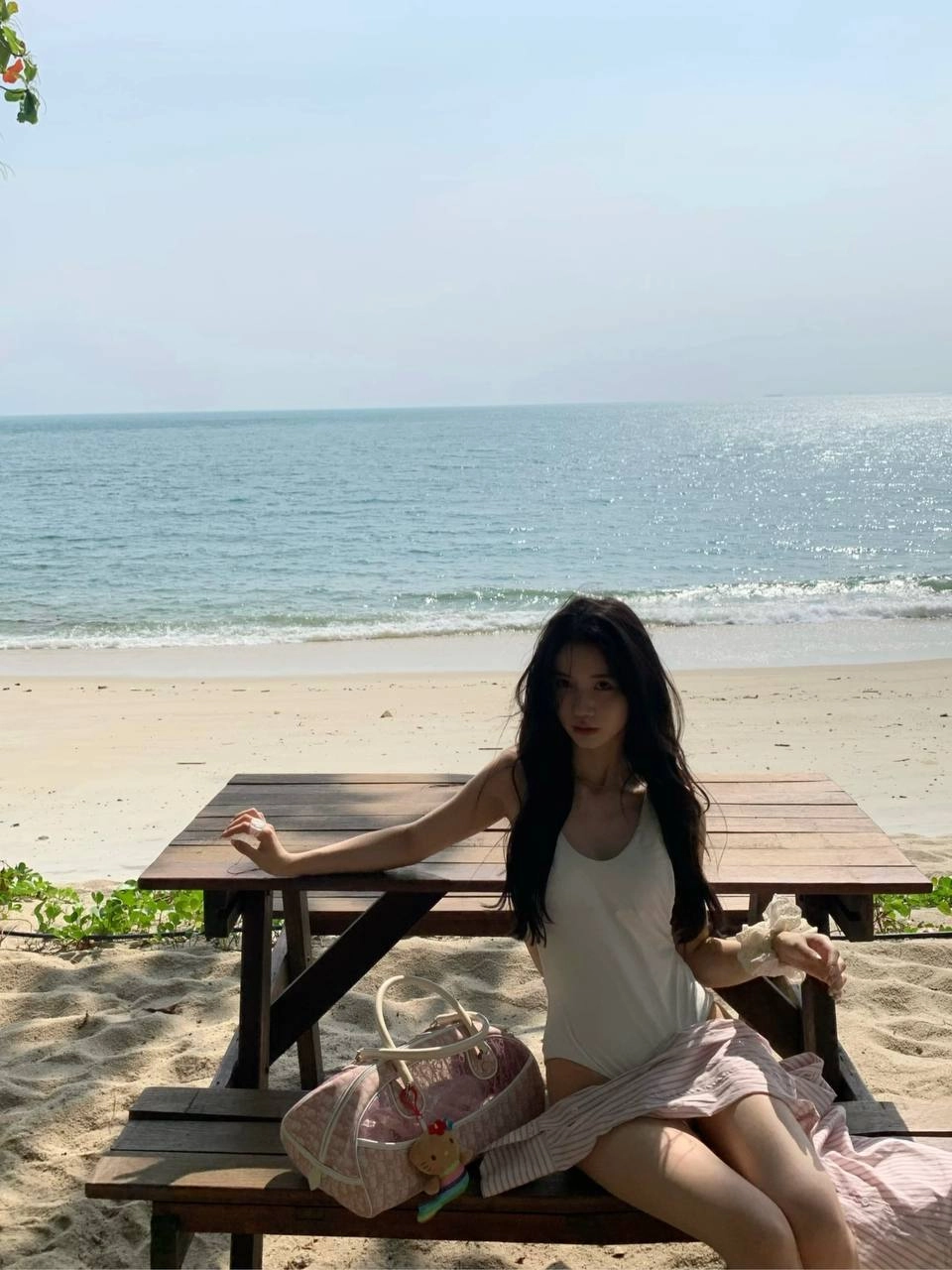 穿着白色衣服的女人坐在沙子上。