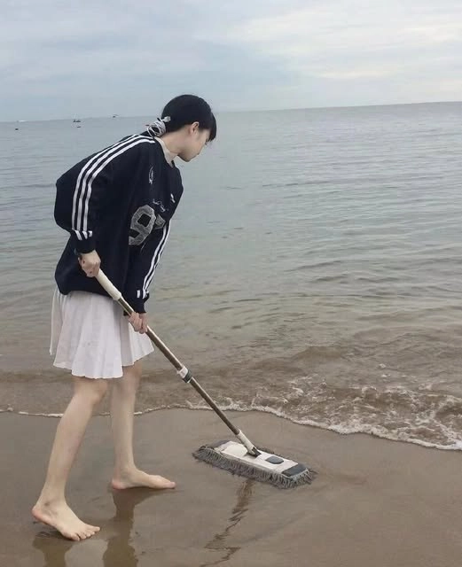 女人在海滩上拿着一根子。