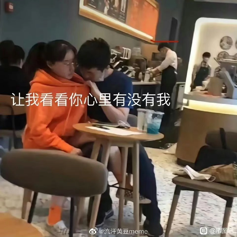 男人和一个女人坐在一张桌子上,一个男人握着一个女人的脖子。