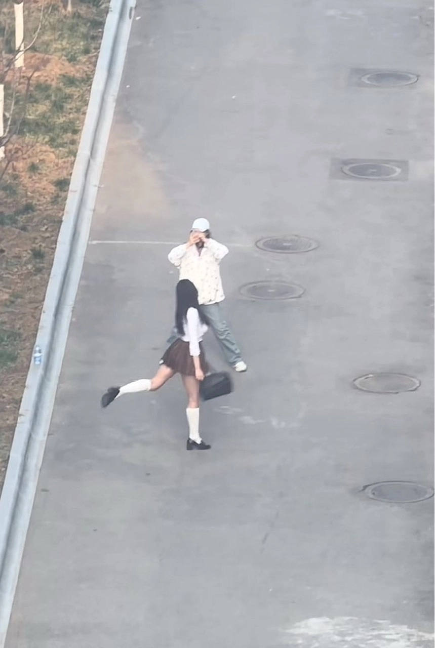 男人和一个女人走在街上,这个男人正在拍照那个女人。